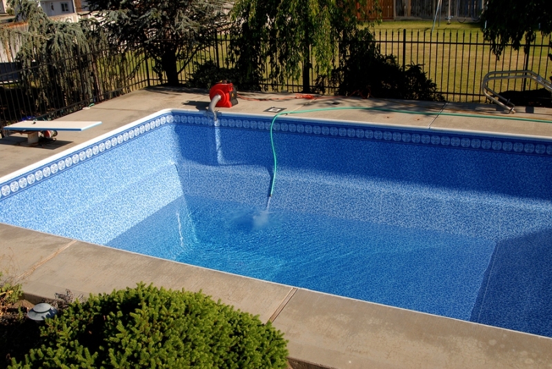 A swimming pool with a new pool liner being filled with water