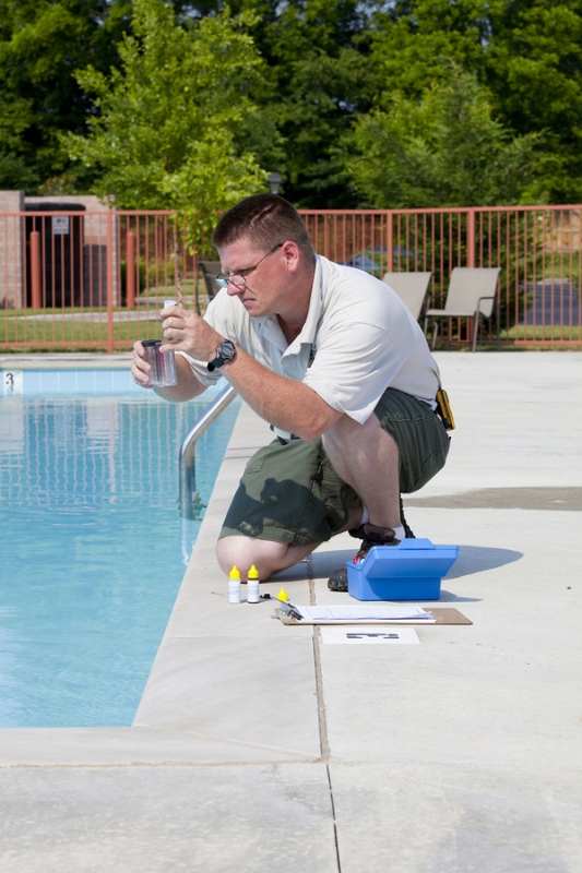 A pool service professional conducting pool chemistry test