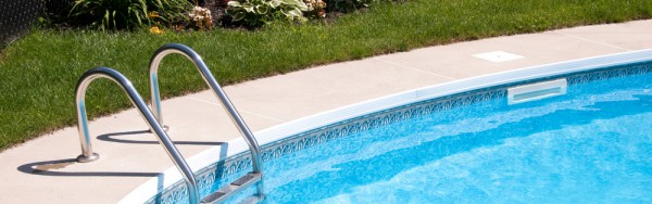 a clear blue pool contrasting with thick green grass