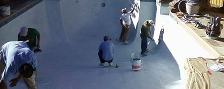 several workers working in a drained pool